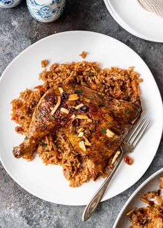 a plate with rice and meat on it next to two plates full of food,