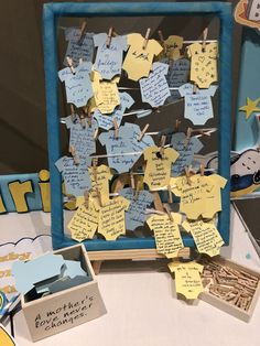 a bulletin board with clothes pins and paper notes attached to the pegs on it