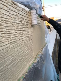 a man is painting the side of a building with white paint on it's walls