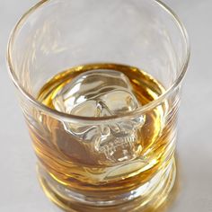 A skull made of ice floats in a glass tumbler filled with amber liquid 3d Skull, Ice Cubes, Williams Sonoma, Ice Cube, Halloween