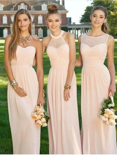 three beautiful women in long dresses posing for the camera