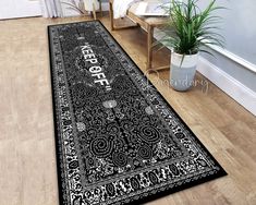 a black and white rug with the words peace on it in front of a wooden floor