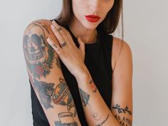 a woman with tattoos on her arm posing for the camera