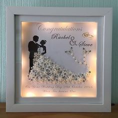 a framed wedding congratulations card with lights on the bottom and an image of a bride and groom