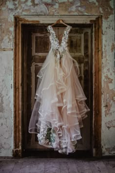 a dress hanging on a door in an old building