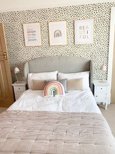 a bedroom with a bed, dressers and pictures hanging on the wall above it