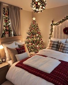 a christmas tree in the corner of a bedroom with lights on and decorations around it