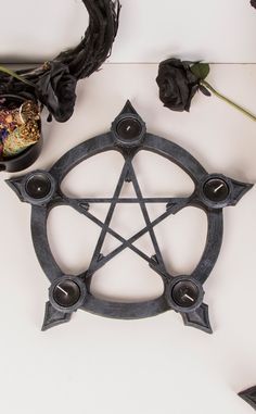 Bring druidess vibes to your altar and dining table. This stone look pentagram has space for tealights at each point as well as holes for stick incense, cast in soft curves resembling the hands of a clock. A wonderful centrepiece for any table needing the soft glow of a warm candle. Each holder comes with 5 tealights and 3 incense sticks as shown. Cast resin. Measures: 40cm Gothic Lifestyle, Tea Lights Centerpieces, Warm Candle, Masquerade Invitations, Alternative Home Decor, Dark Wedding Theme, Unique Homewares, Stick Incense, Heart Cushion