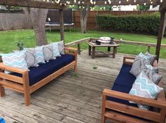 a wooden deck with blue cushions and lights