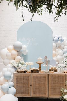 the dessert table is decorated with balloons and cake