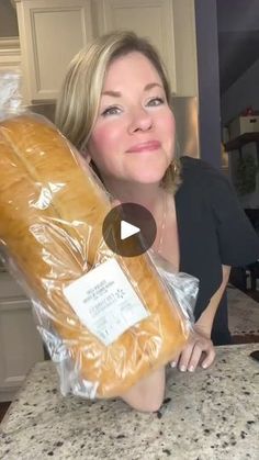 a woman holding a large loaf of bread