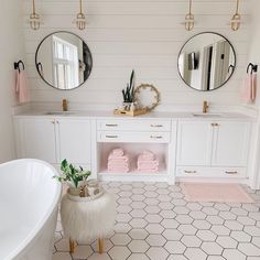 a bathroom with two round mirrors above the bathtub