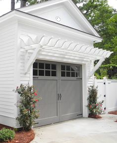 a white house with two garage doors on the side