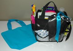 a black bag sitting on top of a white table next to a blue bag with various items in it