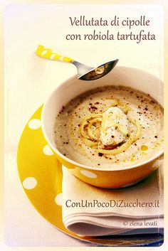 a bowl of soup with a spoon in it on a yellow and white polka dot plate