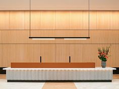 an empty conference room with wooden paneling and flowers in a vase on the table