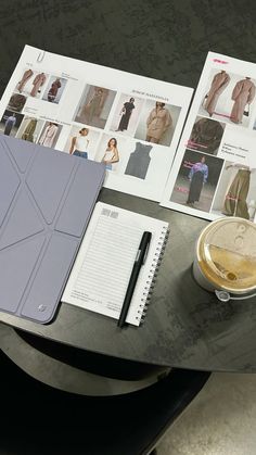 an open book on a table next to a cup and pen