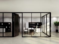 an office with glass walls and black furniture