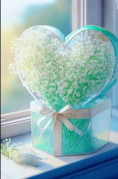 a heart shaped box filled with baby's breath sitting on top of a window sill