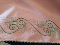 an embroidered pink cloth with green trim