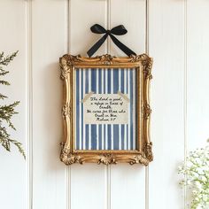 an ornate gold frame hanging on the wall with a black ribbon around it's edge