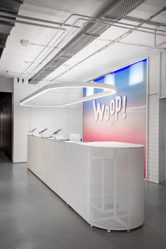 the reception desk is white and has a sign that says woop on it's side