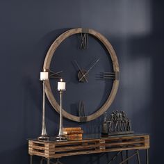 a wooden table with two candles and a clock on the wall