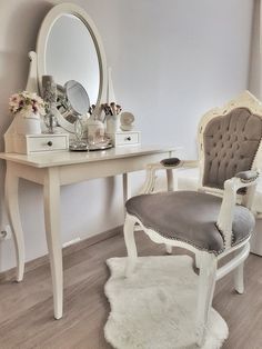 a white vanity with a chair and mirror