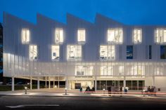 a large white building with lots of windows on it's sides at night time