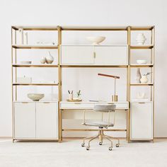 a white desk and chair in front of a book shelf with shelves on each side