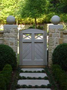 a stone walkway leading to a wooden gate