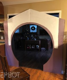 an arch in the middle of a living room with wood flooring and a table