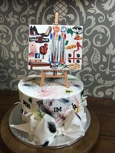 a cake decorated with an easel and paintings