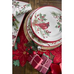 a table topped with plates and christmas decorations