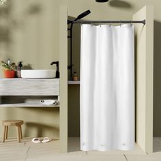 a white shower curtain in a bathroom next to a sink