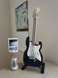 an electric guitar sitting on top of a table next to a cell phone and camera