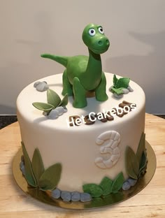 a birthday cake with a dinosaur on top