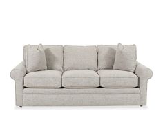 a light colored couch with pillows on the arm and back cushions, in front of a white background