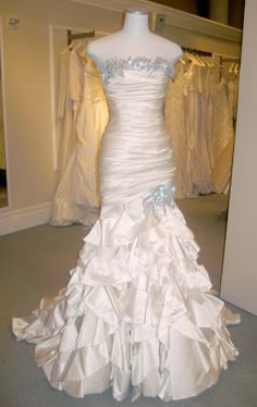 a white wedding dress on display in a room