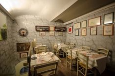 an empty restaurant with tables and chairs in front of pictures on the wall behind them