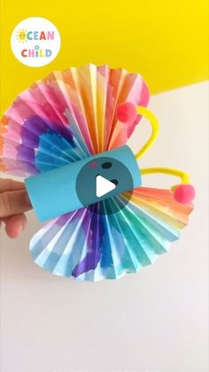 a hand holding up a colorful fan with the words clean child written on it in front of a yellow background