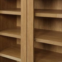 a wooden bookcase with two doors and shelves on both sides, one open to reveal the other side