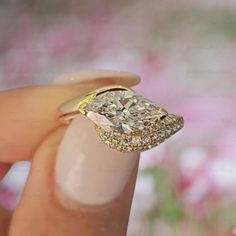 a close up of a person holding a ring with a diamond in it's middle