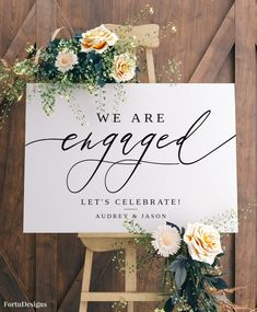 a welcome sign with flowers and greenery sits on top of a wooden easel