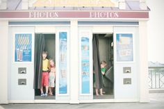 two children standing in the doorway of a photo shop