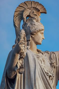 the statue is wearing an elaborate headdress and holding a bird in his hand