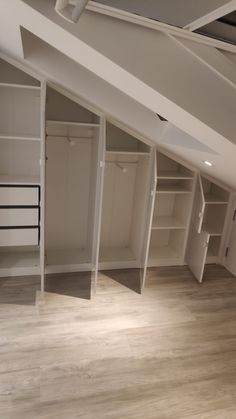 an empty room with white shelves and drawers in the ceiling, while no one is present