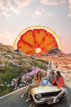 two women sitting on the hood of a car in front of a grapefruit