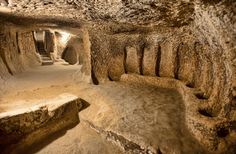 the inside of a cave with some rocks and dirt on it's sides, as well as steps leading up to them