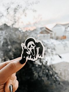 a person holding up a sticker with a skull on it